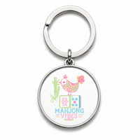 Round Mahjong keychain with pastel mahjong tiles, a bird and a cactus