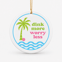 Round ceramic pickleball ornament that says dink more worry less with palm tree