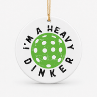 Round ceramic pickleball ornament that says im a heavy dinker around a green pickleball