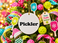 Round ceramic Pickler pickleball ornament hanging on a Christmas tree with pickleball paddle ornaments