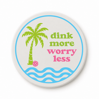 Round ceramic pickleball coaster that says dink more worry less with palm tree and waves